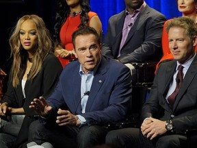 In this Friday, Dec. 9, 2016 photo provided by NBC, Tyra Banks, from left, Arnold Schwarzenegger, Patrick Knapp Schwarzenegger attend a press junket for &ampquot;The New Celebrity Apprentice,&ampquot; in Los Angeles. Schwarzenegger, star of the new version of the television show, is unfazed that President-elect Donald Trump has retained a producer&#039;s stake in the show. Schwarzenegger said Friday that it&#039;s just business, comparable to his situation when he became California&#039;s governor and retained a screen credit