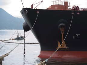 A boat removes the safety oil boom from around a ship at the Kinder Morgan Trans Mountain Expansion Project in Burnaby. Letter writer's duel over the wisdom of exporting more oil through Vancouver.