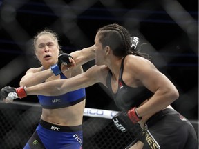 Amanda Nunes, right, throws a punch at Ronda Rousey in the first round of their women's bantamweight championship mixed martial arts bout at UFC 207, Friday, Dec. 30, 2016, in Las Vegas. Nunes won the fight after it was stopped in the first round.