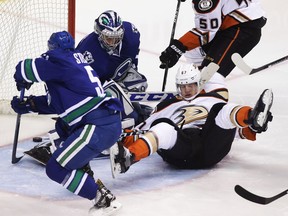 Anaheim Ducks' Rickard Rakell (67) falls to the ice near Vancouver Canucks' goaltender Ryan Miller (30) while Ducks' Hampus Lindholm (not shown) scores during second period NHL hockey action in Vancouver on Friday, December 30, 2016.