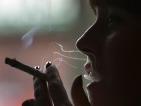 AMSTERDAM, NETHERLANDS - FEBRUARY 07:  A woman smokes a cigarette of marijuana in an Amsterdam cafe on February 7, 2007 in Amsterdam, Netherlands. The city council in Amsterdam has recently voted in favour of introducing a citywide ban on smoking marijuana in public areas. A successful trial ban in the De Baarsjes district of Amsterdam has been declared a success after a reduction in anti social behaviour.