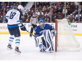 Ryan Miller makes a glove save as Bryan Little looks for the rebound.