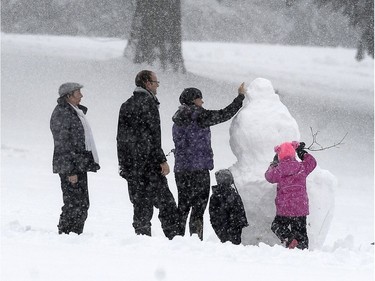 People play in the snow during an Environment Canada snow fall warning on Burnaby Mountain in Burnaby, BC., December 5, 2016.