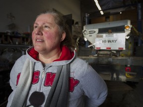 Virginia McMahon, office manager for Arctic Snow Removal, in the service bay with one of the companies five ton salting trucks, Burnaby, December 06 2016.