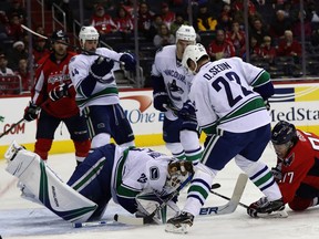 Jacob Markstrom and T.J. Oshie go after the puck in the second period at Verizon Center.