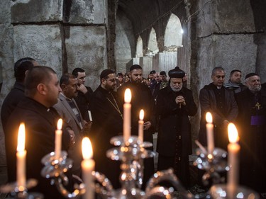 Archbishop Temathous (C) leads a prayer service at the Saint George church on December 24, 2016 in Bartella, Iraq. The predominantly Christian town of Bartella was recently liberated from ISIL as part of the Mosul offensive. The town's four churches were heavily damaged and defaced during the two year occupation. The Christmas mass marks the first official mass in Bartella since a mass was held on August 14, 2014 just hours before ISIS arrived. Christian communities around Mosul are celebrating Christmas as the Mosul offensive continues.