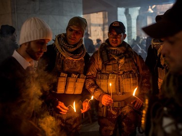 Soldiers from the Iraqi Army Special Forces light candles during the Christmas mass at the Mar Shimoni Church on December 24, 2016 in Bartella, Iraq. The predominantly Christian town of Bartella was recently liberated from ISIL as part of the Mosul offensive. The town's four churches were heavily damaged and defaced during the two year occupation. The Christmas mass marks the first official mass in Bartella since a mass was held on August 14, 2014 just hours before ISIS arrived. Christian communities around Mosul are celebrating Christmas as the Mosul offensive continues.