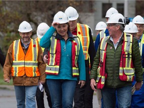 B.C. Premier Christy Clark, centre left, adjusts her hard hat as she arrives for an announcement at the Woodfibre LNG project site near Squamish, B.C., on Friday November 4, 2016. Woodfibre LNG says it is proceeding with its proposed liquefied natural gas development, in what would be the province's first LNG project.
