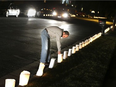 David Kee of Winchester, Va., lights luminarias in front of his home Saturday, Dec. 24, 2016. This is the 30th year residents in the community have lined the streets in front of their homes with luminarias on Christmas Eve.