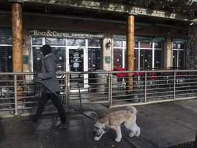 A woman walks past the Rose and Crown Pub where police found a 53-year-old man unconscious.