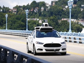 Uber employees test a self-driving Ford Fusion hybrid car in Pittsburgh last summer. After taking millions of factory jobs, robots could be coming for a new class of worker: people who drive for a living.