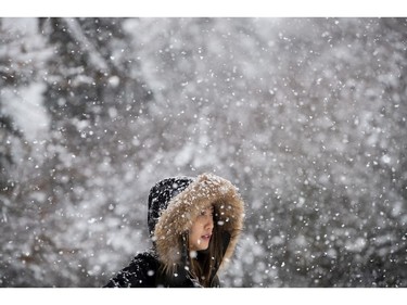 Fiona Zhang walks through falling snow at Queen Elizabeth Park in Vancouver, B.C., on Monday December 5, 2016. Environment Canada has issued a snowfall warning for Metro Vancouver.