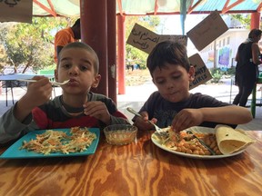 Refugee boys tucking into cole slaw, chick peas and chicken soup.