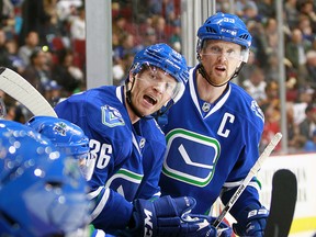 Jannik Hansen #36 and Henrik Sedin #33 of the Vancouver Canucks react to a play against the Winnipeg Jets during their NHL game at Rogers Arena December 20, 2016 in Vancouver, British Columbia, Canada.