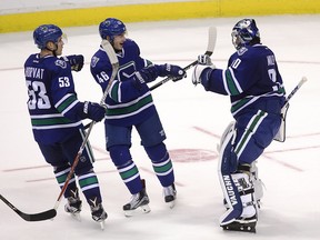 Vancouver Canucks goaltender Ryan Miller (30) celebrates his team's win with teammates Bo Horvat (53) and Jayson Megna (46) following the shootout.