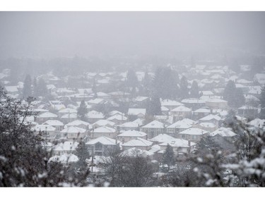 Roofs of houses are covered in snow as seen from Queen Elizabeth Park as snow falls in Vancouver, B.C., on Monday December 5, 2016. Environment Canada has issued a snowfall warning for Metro Vancouver.