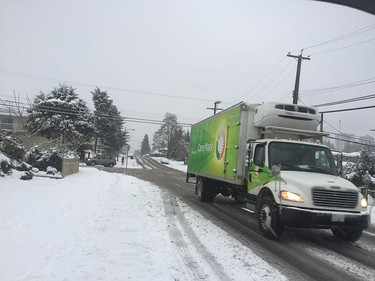 A truck crosses a slushy street in Burnaby as snow hits Metro Vancouver on December 9, 2016.