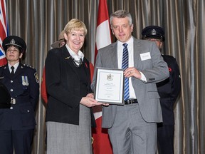 Det. Const. Jim Fisher (right) accepts a 2014 Community Safety and Crime Prevention Award from Attorney General and Minister of Justice Suzanne Anton.
