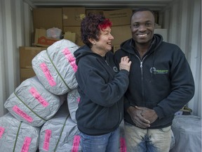 Eric Manu, right, and Susan Watson show off donated goods being collected to send to Ghana.