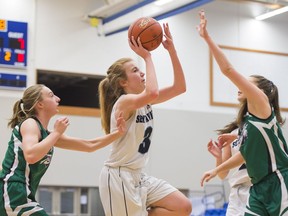 Seycove Seyhawks Ashley Bradshaw (3) puts up a shot after getting past Riverside Rapids Adrienne Willems (left) and Tessa Burton during the opening game of the Tsumura Basketball Invitational in Langley, BC, December, 15, 2016.