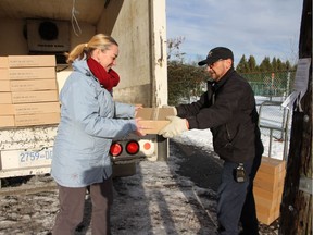 Mount Pleasant principal Jann Schmidt helps delivery driver Terry Fisher unload 20 cases of tuna donated to the school by Richmond's Blundell Seafoods. They will be distributed to impoverished families.