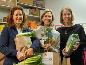 Packing food for hungry families in Queen Alexandra's Wishing Tree free food store is (from left) Tracey MacKinlay, Pam Bragagnolo and principal Megan Davies.