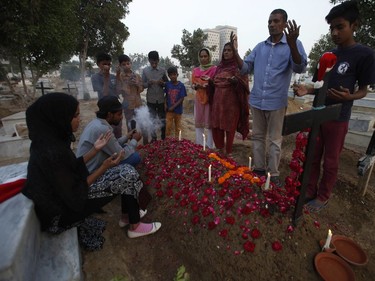 Pakistani Christians visit a grave of their family member at a graveyard ahead of Christmas in Karachi, Pakistan, Saturday, Dec. 24, 2016.