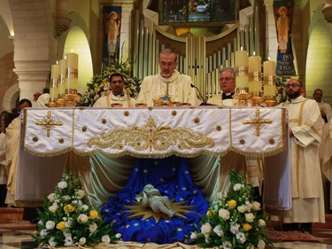Archbishop Pierbattista Pizzaballa (C), apostolic administrator of the Latin Patriarch of Jerusalem, leads the Christmas Midnight Mass in Saint Catherine's Church at the Church of the Nativity, where Christians believe the Virgin Mary gave birth to Jesus Christ, in the adjacent Church of the Nativity on December 25, 2016 in Bethlehem, West Bank.
