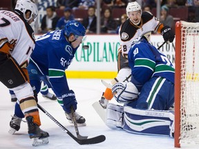 Vancouver Canucks' Troy Stecher, second left, is hit by the puck after goalie Ryan Miller, front right, stopped Anaheim Ducks' Logan Shaw, back right, as Ryan Kesler, left, watches during the first period of an NHL hockey game in Vancouver, B.C., on Thursday December 1, 2016.