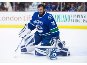 Vancouver Canucks' goalie Ryan Miller loses his mask after being struck by a puck.