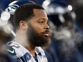 Michael Bennett of the Seattle Seahawks watches action during the first half of a game against the Green Bay Packers at Lambeau Field on December 11, 2016 in Green Bay, Wisconsin.