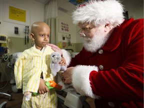 Santa Claus brightened the day for many while paying an early visit to Surrey Memorial Hospital on Dec. 20. Here, young cancer patient Jithu Srikanth gets some words from Santa. The jolly man made his appearance by helicopter, landing on the roof of the hospital in style.
