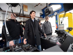 Prime Minister Justin Trudeau steers a tugboat in Vancouver Harbour, Tuesday, Dec.20, 2016.