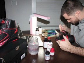 Zac Vine of Zeevy Customs is a shoe designer who paints images on sneakers for shoe fanatics around the world. The 31-year-old Vancouver artist will be in attendance at the Ultimate Sneaker Show on Dec. 17 at the Vancouver Convention Centre. Here, he's working on a pair of shoes in his home studio. — Chasthylyn Kanealii