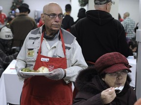 Joseph Sequeira, 85 years old and "the happiest man in the world," serves dinner at the Salvation Army Harbour Light's annual Christmas dinner in Vancouver.