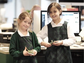 York House students Jessica Atkinson and Anna Julia Rogo bring their original $298.80 proceeds to The Vancouver Sun newsroom in November.