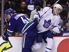 Canucks Erik Gudbranson, left, checks Toronto Maple Leafs Nazem Kadri during first-period NHL action in Vancouver on Saturday.
