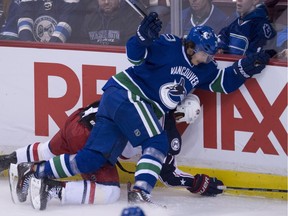 Vancouver Canucks left wing Loui Eriksson (21) puts Columbus Blue Jackets centre Brandon Dubinsky (17) into the boards during third period NHL action in Vancouver, B.C. Sunday, Dec. 18, 2016.