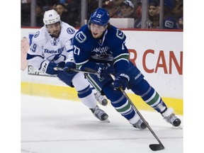 Defenceman Ben Hutton of the Vancouver Canucks moves the puck up ice while being pursued by Cory Conacher of the Tampa Bay Lightning during Friday's NHL game at Rogers Arena in Vancouver.