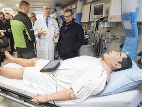 Dr. Eric Grafstein (middle) who is an emergency doctor at St. Paul's Hospital briefs B.C. Health Minister Terry Lake on how the mobile medical unit will work in the Downtown Eastside in Vancouver, BC, December, 12, 2016.