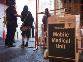 A paramedic tries to convince an overdose victim to go in to the Mobile Medical Unit in the Downtown Eastside of Vancouver, BC, December, 21, 2016.