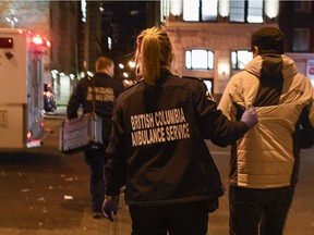 The number of illicit drug overdose deaths dropped slightly for the second straight month in February in British Columbia, but the coroner's service says the numbers are still much higher compared with a year ago. A paramedic guides an overdose patient to the ambulance for transport in the Downtown Eastside of Vancouver, BC, December, 21, 2016.