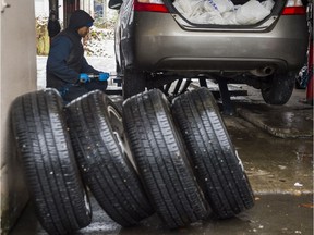 Michael Alleyne of Big-O Tires on West Broadway is busy putting on snow tires on a car in Vancouver,. Getting snow tires and learning to drive when it slippery are basics, but many in Metro prefer griping about snow instead.
