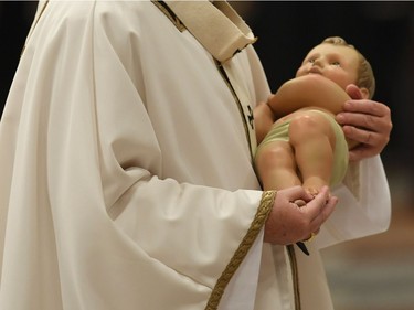 Pope Francis carries the statue of baby Jesus during a mass on Christmas eve marking the birth of Jesus Christ on December 24, 2016 at St Peter's basilica in Vatican&ampgt;