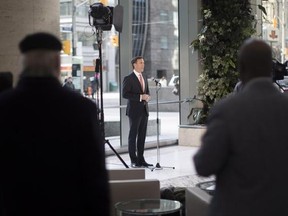 Bystanders watch as Federal Finance Minister Bill Morneau briefs journalists following a meeting with leading private sector economists in Toronto, on Friday January 13, 2017. THE CANADIAN PRESS/Chris Young