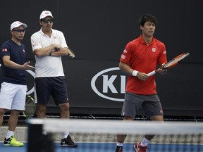 Japan&#039;s Kei Nishikori, right, prepares to hit the ball as his coaches Michael Chang, left, and Dante Bottini, second left, confer during a practice session at the Australian open tennis championship in Melbourne, Australia, Saturday, Jan. 14, 2017. (AP Photo/Dita Alangkara)