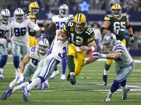 Green Bay Packers quarterback Aaron Rodgers (12) rushes for a gain as Dallas Cowboys&#039; Sean Lee (50) and Anthony Brown (30) defend during the second half of an NFL divisional playoff football game Sunday, Jan. 15, 2017, in Arlington, Texas. (AP Photo/Michael Ainsworth)