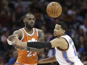 Cleveland Cavaliers&#039; LeBron James, left, passes against Oklahoma City Thunder&#039; Andre Roberson in the second half of an NBA basketball game, Sunday, Jan. 29, 2017, in Cleveland. (AP Photo/Tony Dejak)
