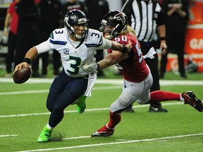 Russell Wilson #3 of the Seattle Seahawks scrambles away from Brooks Reed #50 of the Atlanta Falcons at the Georgia Dome on January 14, 2017 in Atlanta, Georgia.