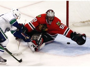 Vancouver Canucks center Bo Horvat, left, scores against Chicago Blackhawks goalie Corey crawford during the third period of an NHL hockey game, Sunday, Jan. 22, 2017, in Chicago.